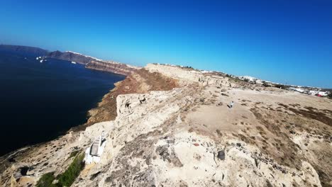 Flight-over-of-traditional-terraced-white-church-in-Santorini,-Greece