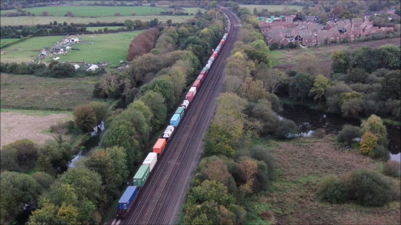 грузовой поезд, проезжающий по рельсам, воздушный снимок дрона