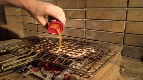 Slow-Motion-Shot-of-Man-Adding-More-Seasoning-to-Grilled-Chicken-on-a-Charcoal-BBQ-at-Night