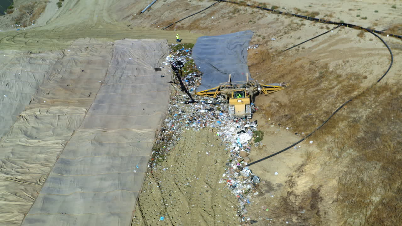 Aerial View of a Landfill with Heavy Machinery Pushing Waste