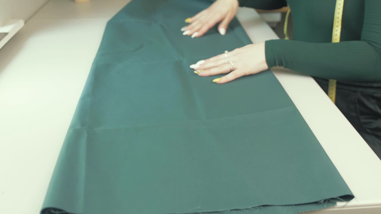 costurera mujer desplegando tela verde