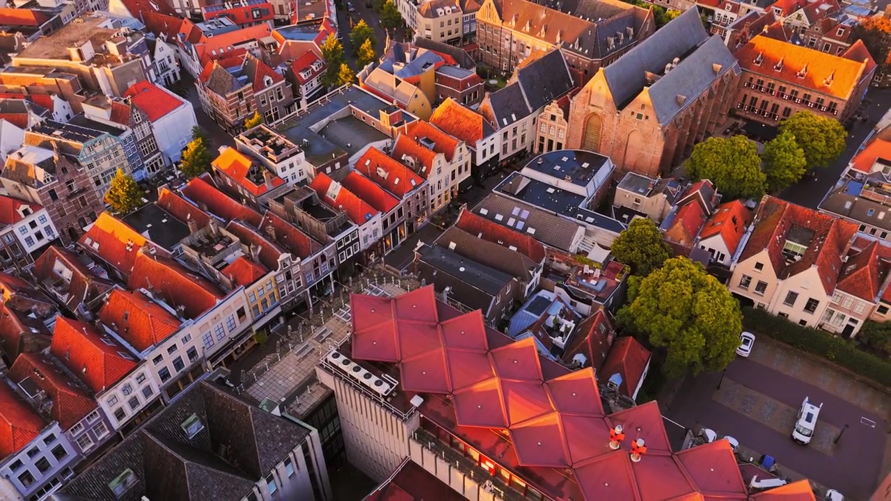 Veduta aerea all'ora d'oro di Zwolle, Paesi Bassi, che mostra fitti tetti storici, strade strette e una distintiva struttura di tetto moderna all'interno del centro storico.