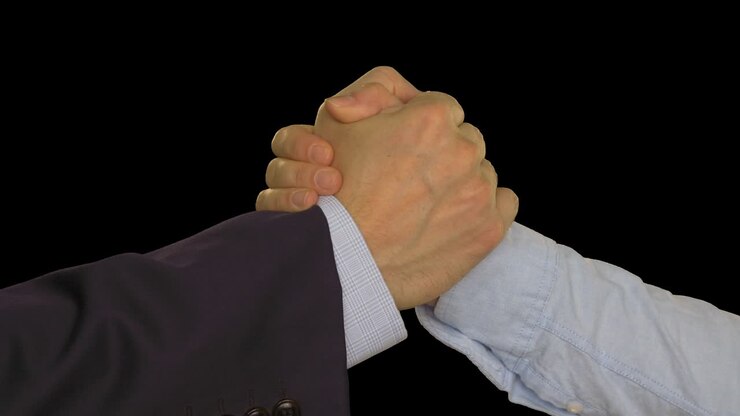 Two hands joining together after deal. Businessman and businesswoman shaking hands