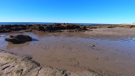 pan right from the tide going out to the now revealed beach and sea bottom, puerto peñasco, gulf of california, mexico