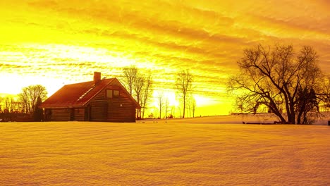 Golden,-vibrant-sunrise-in-winter-with-a-cozy-cabin-in-the-foreground---time-lapse