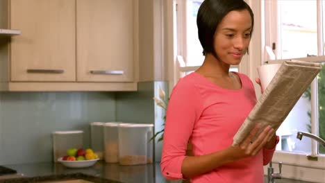 Pretty-woman-drinking-and-reading-newspaper