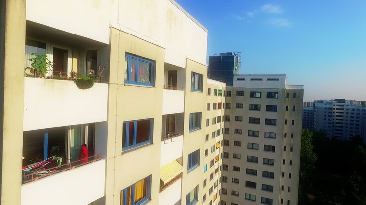 Drone sobe verticalmente ao longo da fachada de um prédio residencial branco na Alemanha