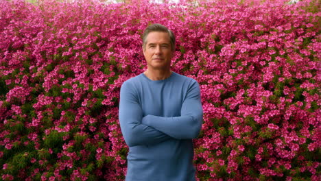 Man Posing in Front of Pink Flower Bush