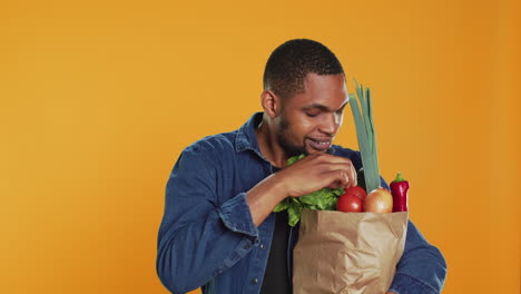 hombre vegano admirando frutas y verduras recién cosechadas