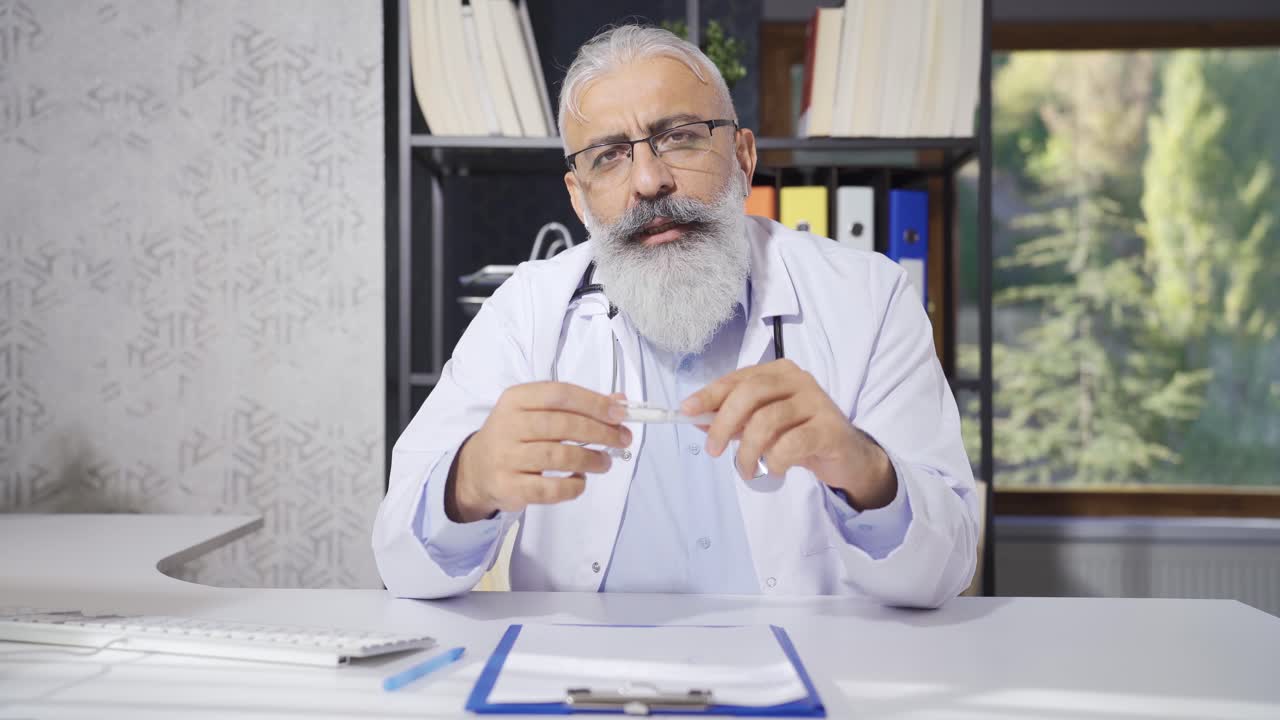 Senior doctor talking looking at camera.