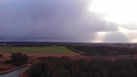 Aerial-View-Of-Fields-In-Zwijndrecht-With-Dramatic-Sunbeams-In-Distance