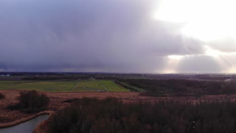 aerial view of fields in zwijndrecht with dramatic sunbeams in distance