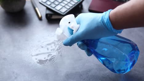 cleaning a desk with spray bottle