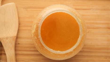 miel en un frasco de vidrio en una bandeja de madera