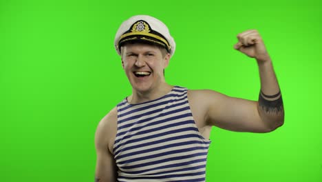 young sailor man celebrates yelling emotionally and raises his hands. seaman guy