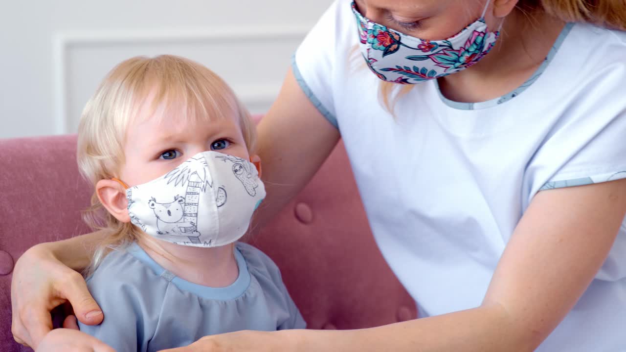 Mother helping child put on a face mask