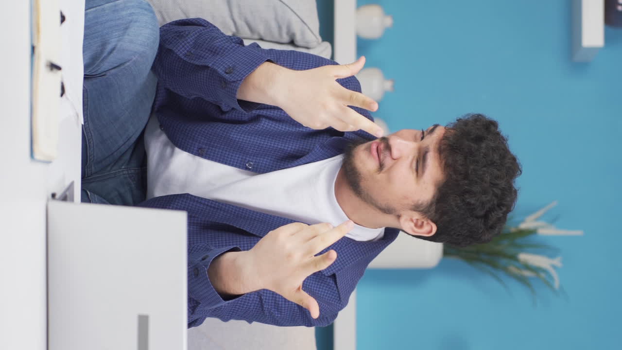 재미있는 남자가 카메라를 조롱하는 수직 비디오.