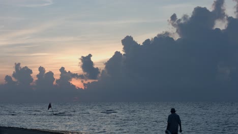 Einsamer-Mann,-Der-In-Der-Dämmerung-Am-Strand-Spazieren-Geht