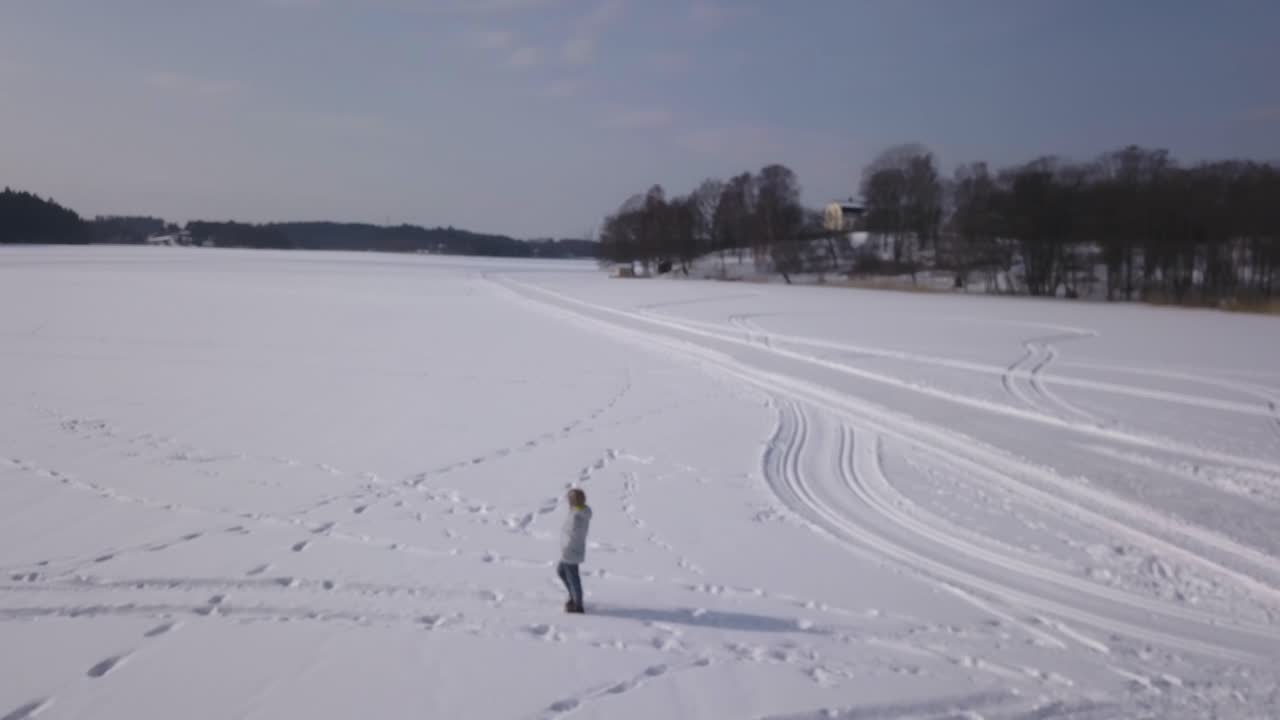 Winter landscape with a person walking on a frozen lake