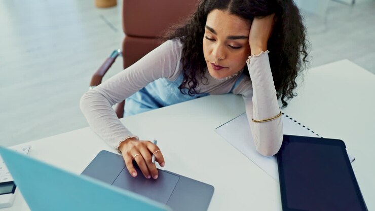 Donna che lavora al laptop, stressata e stanca