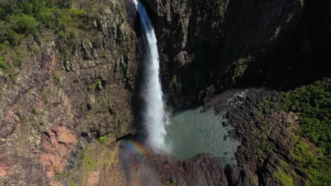 wallaman falls, water cascading over canyon horsetail waterfall, aerial arc shot