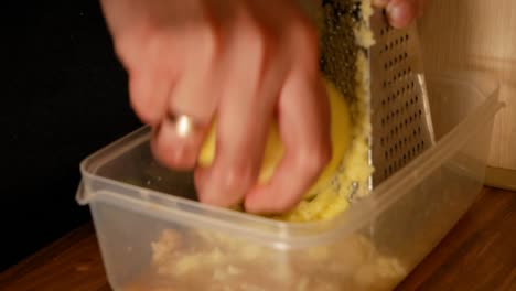 peeled, raw potatoes being grated by a married man in homemade kitche