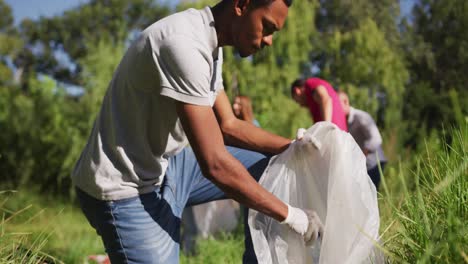 African-American-man-looking-and-smiling-at-camera-during-river-clean-up-day