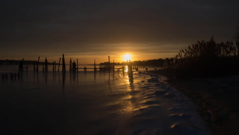 sunrise over a frozen river on a crisp cold morning at some delipidated docks