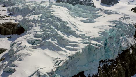 slow aerial shot of snow covered mountain glacier, outdoor during summer