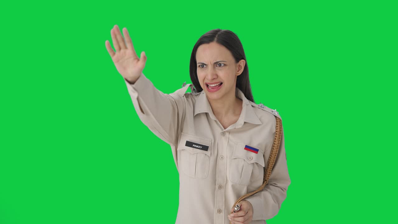 Arrabbiata agente di polizia indiana che ferma qualcuno con un fischietto su green screen