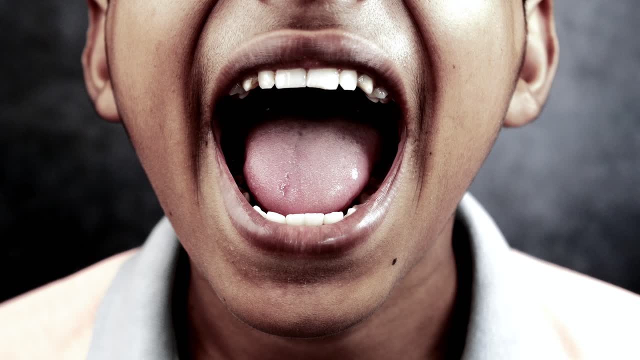 un adolescente gritando a la cámara ,