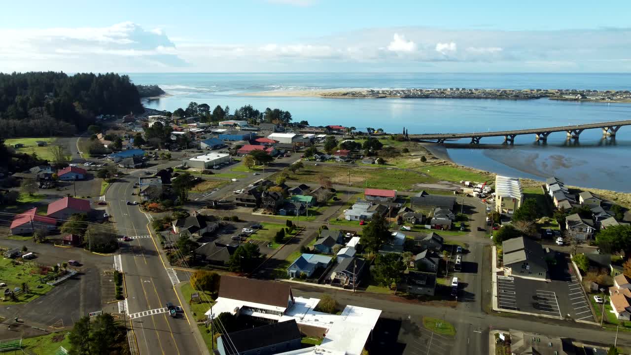 estados unidos, o, waldport,, 2024-11-26 - vista de avión no tripulado sobre la ciudad de waldport con el puente alsea cruzando el río alsea a la derecha, bayshore en la playa y el océano pacífico más allá.
