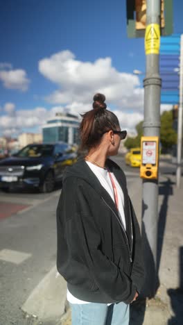 woman waiting at crosswalk in city