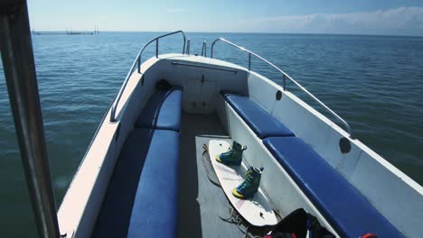 Wakeboard-Boot-Mit-Brett-Zum-Wasserskifahren,-Das-Auf-Dem-Meer-Vor-Der-Skyline-Im-Hintergrund-Schwimmt