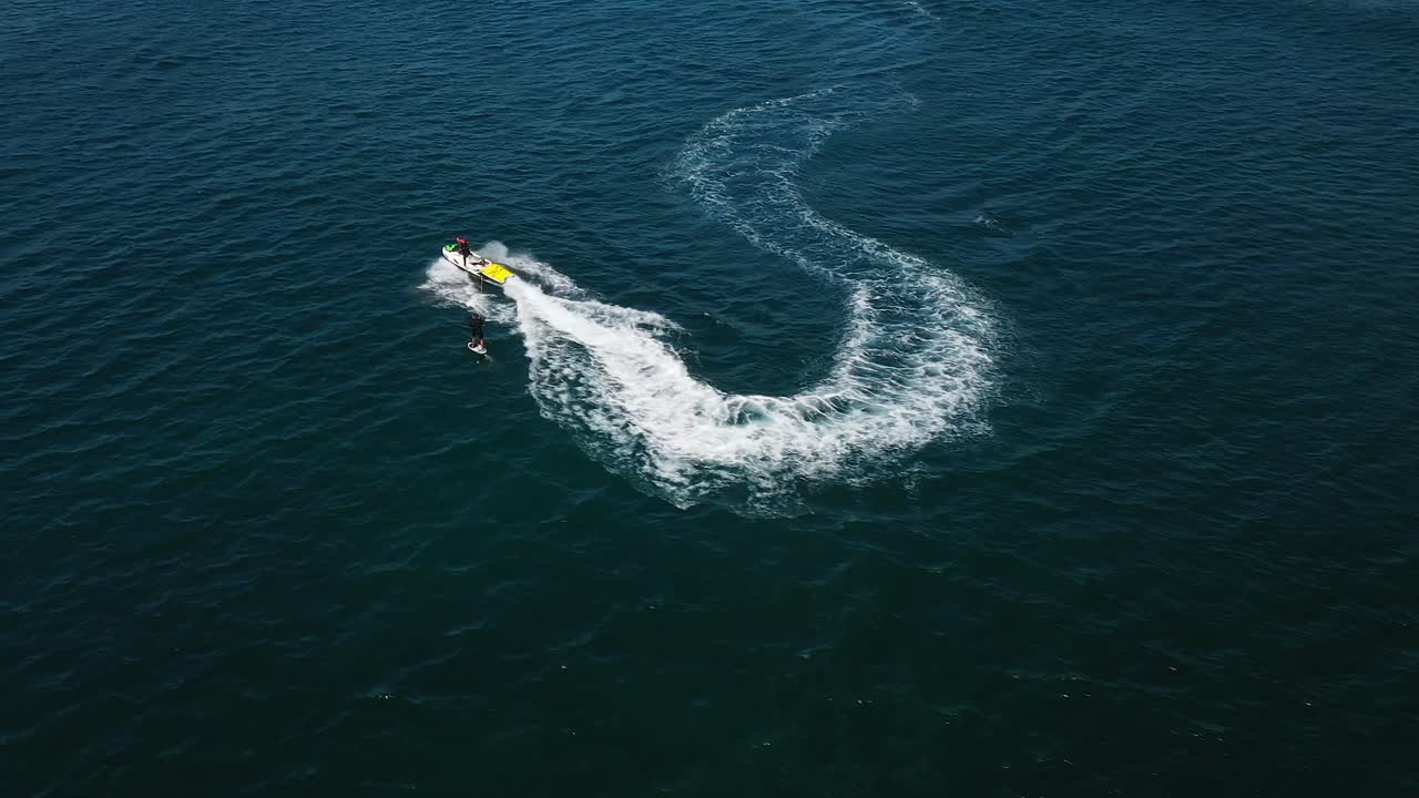 jet ski remolque aéreo atleta de foiling en el océano, deportes acuáticos desde arriba, disparo de drones