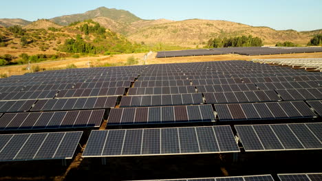 Low drone flight over photovoltaic solar panels in Chile countryside