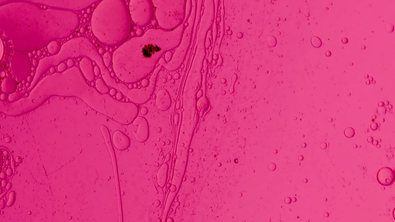 fondo abstracto de gotas de aceite en líquido rosa para tratamientos cosméticos