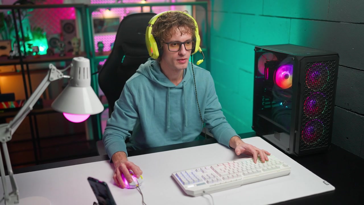 Mladý muž hrající videohry na herním PC s headsetem