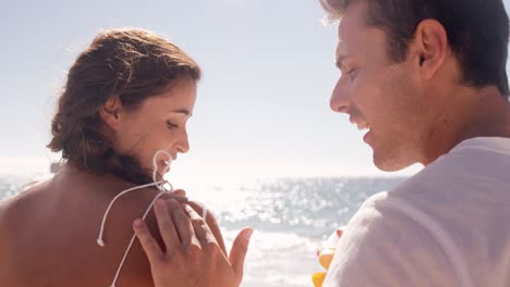 man putting sunscreen to his girlfriend