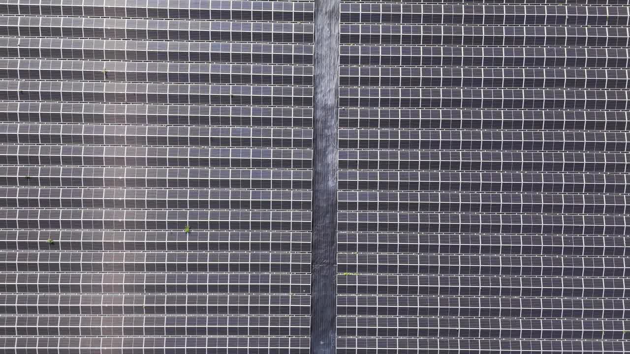 Ampia prospettiva aerea da drone di un grande impianto solare con molti pannelli fotovoltaici allineati