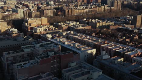 diagonal aerial trucking shot across the upper part of harlem new york city in golden hour