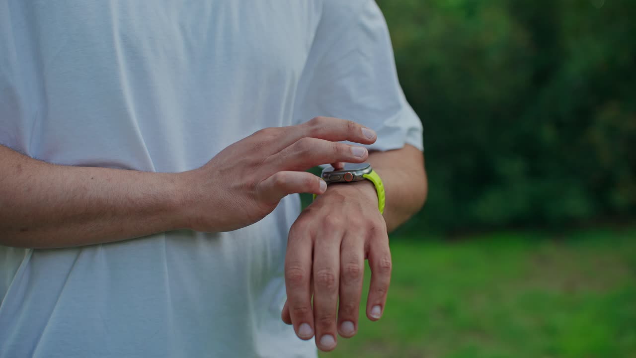Nærbilde av en person som sjekker smartklokken sin utendørs
