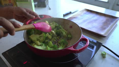 cooking stir-fried broccoli in a red pot