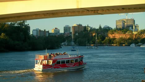 cityhopper ferry boat cruising in the brisbane river at sunset in brisbane, qld, australia