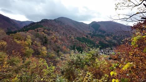 scenic autumn panorama of shirakawa-go village nestled in a vibrant forested valley.