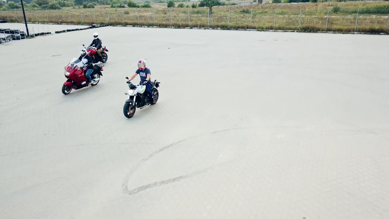 Three motocyclists men riding their vehicles in a high speed outdoors. Professional motobikers in protective helmets drive on the road at daytime.