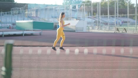 woman jogging on outdoor track in sportswear at athletic field