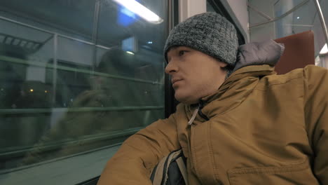 commuter man traveling by train in winter evening