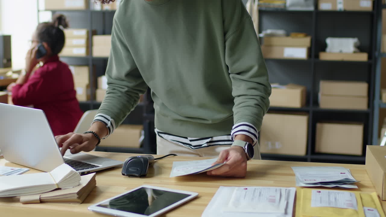 Man packaging items for shipping in an office setting