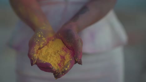 slow motion close up of female hands full of colorful powder for indian holi festival of spring and love